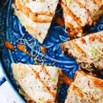 Beef quesadilla served in a blue plate with sauce
