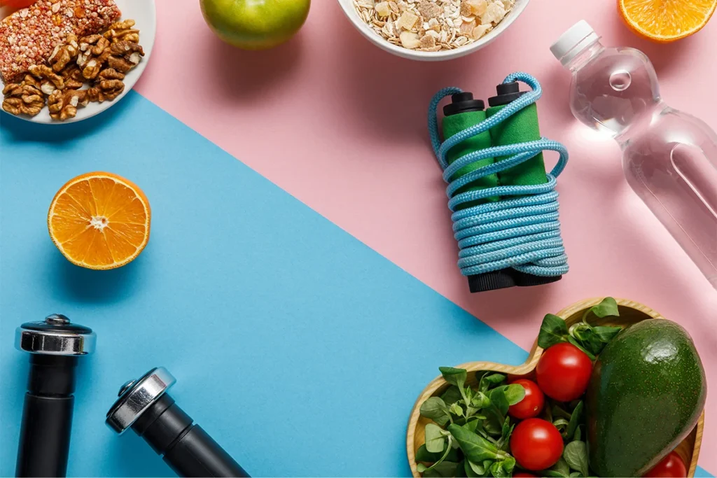 Healthy Food, water, skipping rope, dumbbells on blue and pink background for Health Wellness Tips