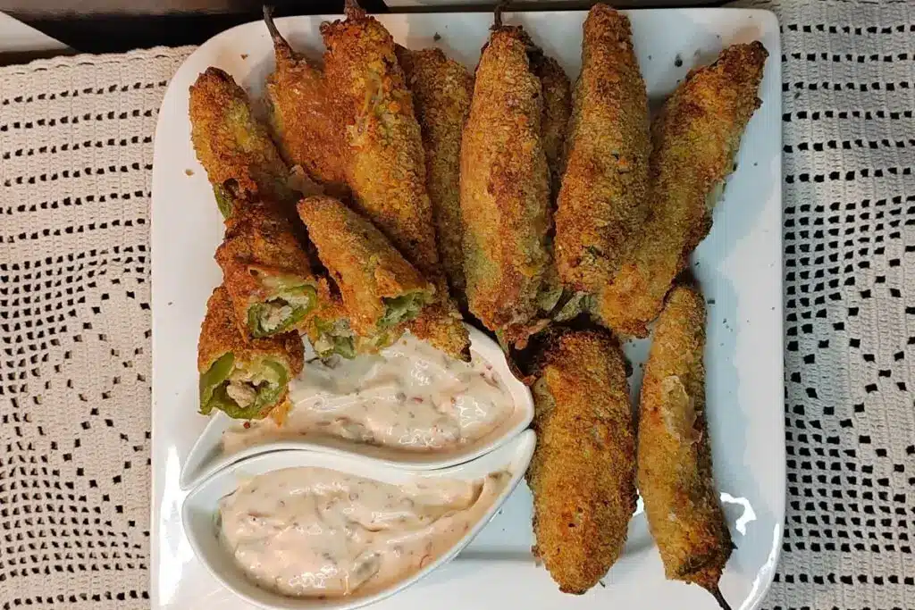 Top view of air fried peri bites served with chili garlic mayo sauce in a white square plater