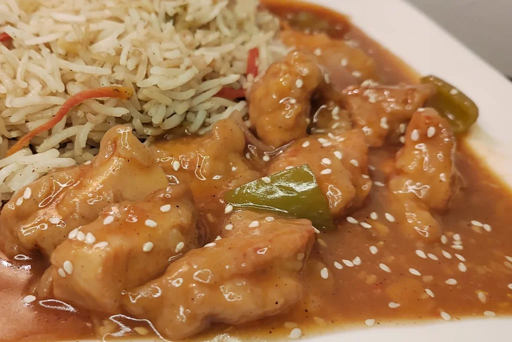 Chicken Manchurian served with egg fried rice topped with sesame seeds