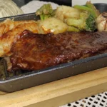 Beef Striploin Steak with mashed Potatoes served in cast iron sizzler dish