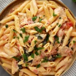 Top View of Marry me chicken pasta with sundried tomatoes and parmesan cheese served in a plate